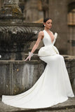 Woman in a white wedding dress sitting by a fountain